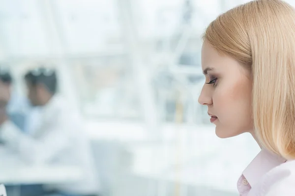 Junge Geschäftsfrau sitzt im Büro — Stockfoto