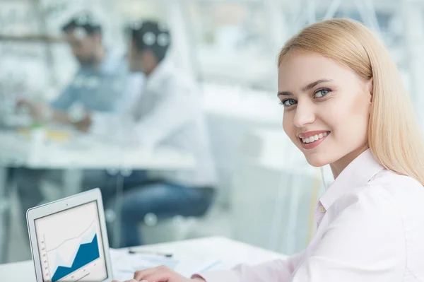 Junge Geschäftsfrau sitzt im Büro — Stockfoto