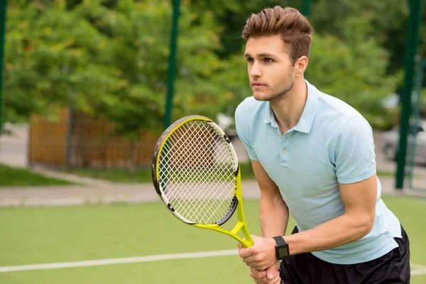 Przystojny młody sportowiec, grając w tenisa — Zdjęcie stockowe
