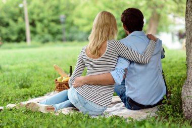 Neşeli erkek ve kadın doğada sarılıyorlar.