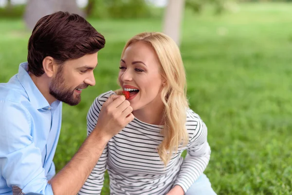 Счастливый мужчина кормит женщину ягодами — стоковое фото