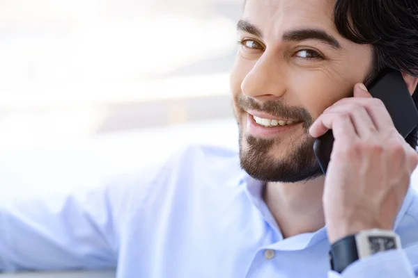 Joyful manliga arbetstagare talar på telefon — Stockfoto