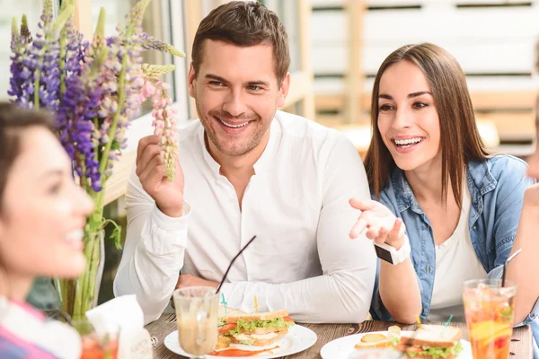 Gelukkige vrienden lunchen in café — Stockfoto