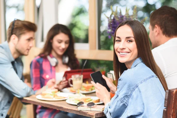 Amigos felices almorzando en la cafetería — Foto de Stock