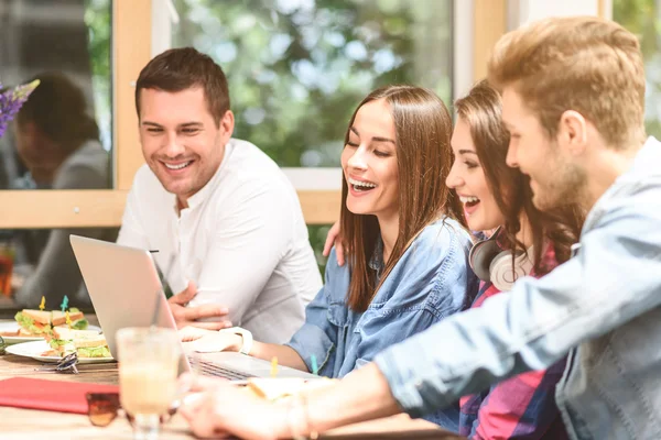 Vier vrienden in koffie winkel met behulp van laptop — Stockfoto