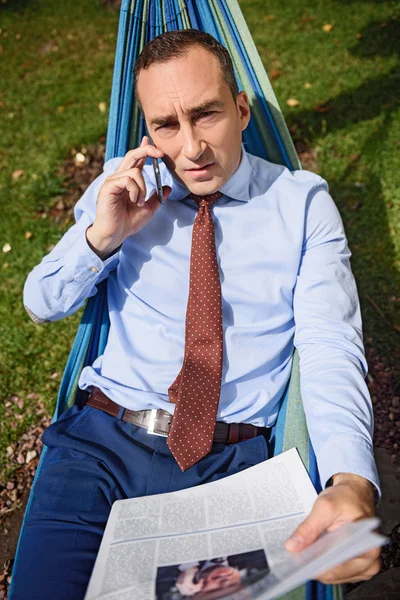 Задумчивый человек разговаривает по телефону во время отдыха — стоковое фото