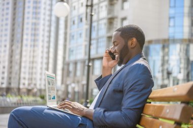 Telefon açık havada üzerinde konuşan neşeli genç adam
