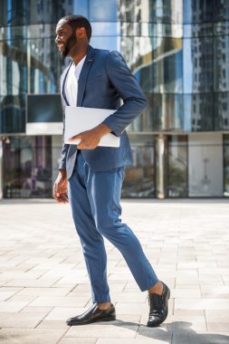 Şehirdeki bilgisayar ile neşeli Afrika işadamı