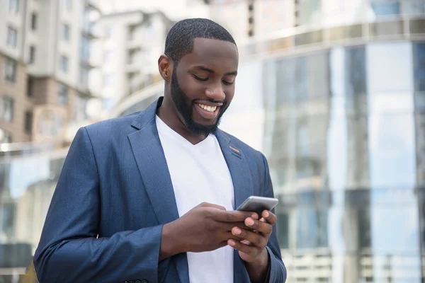Afrikaanse zakenman messaging in grote stad — Stockfoto