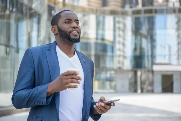 Neşeli Afrika adam akıllı telefon üzerinde dinlenme kullanarak — Stok fotoğraf