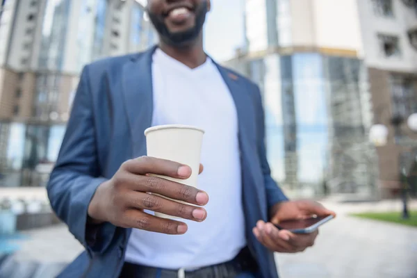 Vrolijke jongeman genieten van warme dranken buiten — Stockfoto