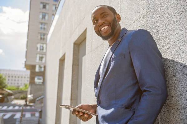 Alegre trabajador masculino con tecnología moderna en la ciudad —  Fotos de Stock