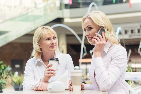 Córka przy użyciu telefonu, podczas gdy mama czeka — Zdjęcie stockowe