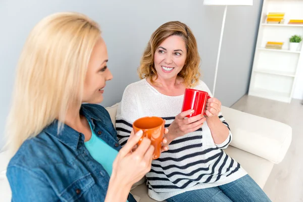 Linda familia charlando con bebidas en casa — Foto de Stock