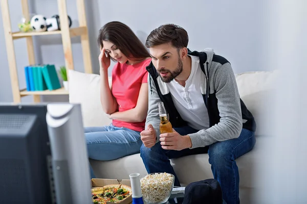 Мужчина и женщина смотрят телевизор на диване — стоковое фото
