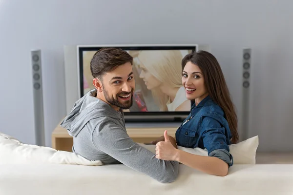Мужчина и женщина смотрят телевизор на диване — стоковое фото
