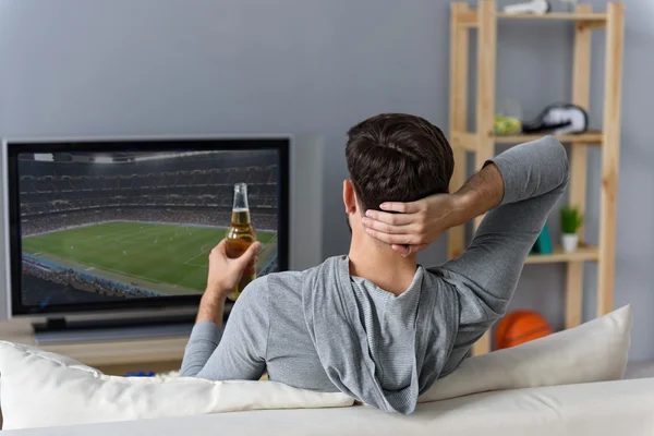 Jovem assistindo televisão em casa — Fotografia de Stock