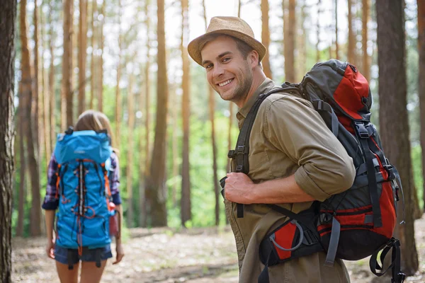 Touristes joyeux marchant dans la forêt — Photo