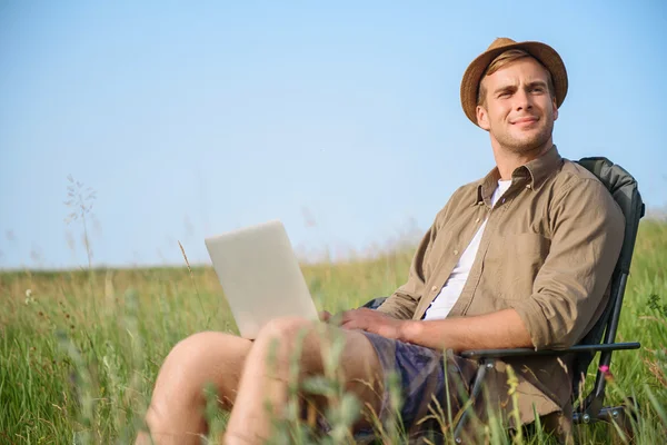 Cara saudável relaxante no prado com laptop — Fotografia de Stock
