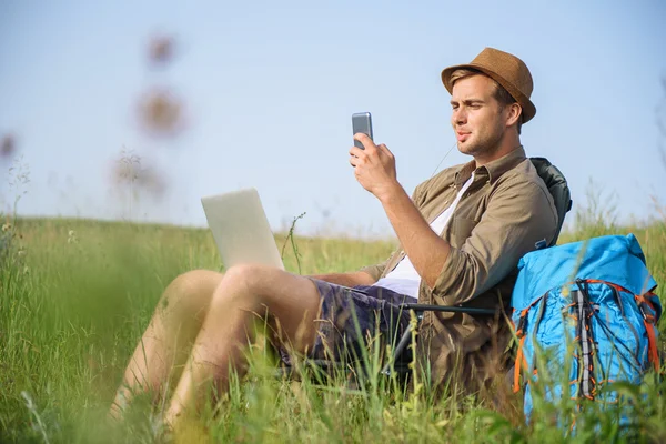 Cara relaxante com gadgets modernos na natureza — Fotografia de Stock