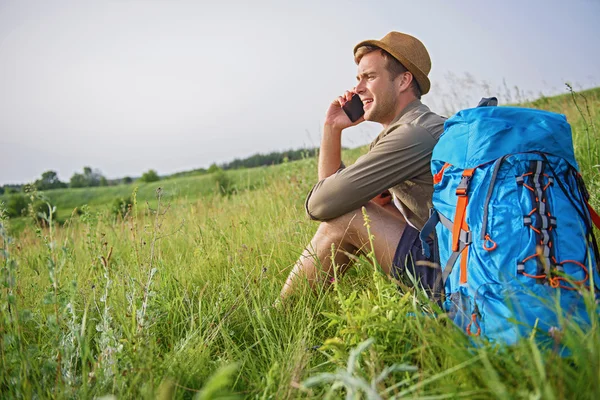 Bello turista utilizzando il telefono in prato — Foto Stock