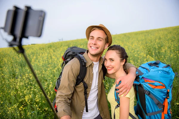Boldog férfi és a nő, hogy selfie a természetben — Stock Fotó