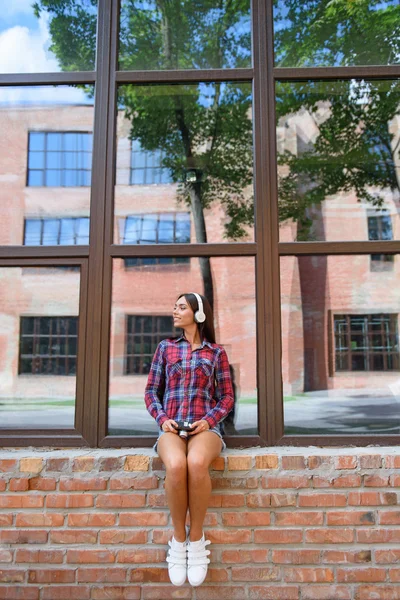 Mujer alegre descansando en el alféizar de la ventana al aire libre — Foto de Stock