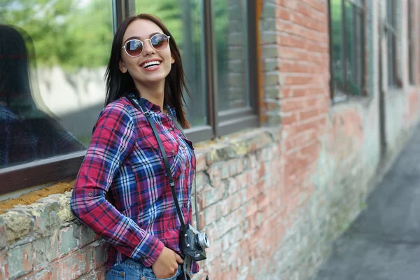 Happy young woman resting near building — Stock Photo, Image