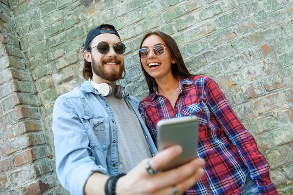 Alegre cara e menina usando telefone — Fotografia de Stock