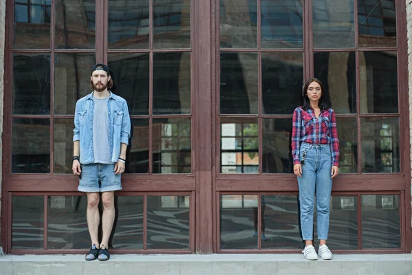 Serious hipster couple stands near building — Stock Photo, Image