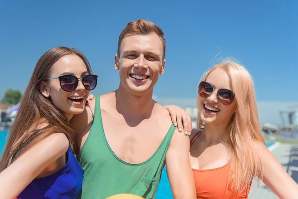 Ragazzo spensierato e ragazze rilassante vicino all'acqua — Foto Stock