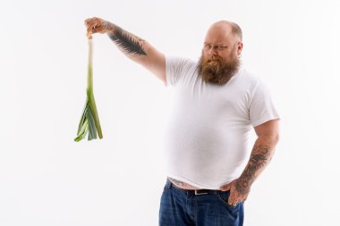 Şişman sakallı adam sebze bakarak