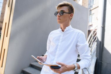 Neşeli adam merdivende gadget ile bekliyor