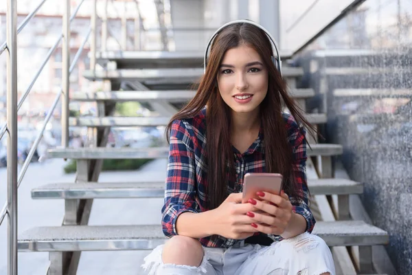 Chica alegre escuchando melodía desde el teléfono inteligente — Foto de Stock