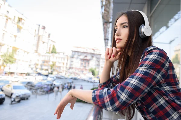 屋外でイヤホンでリラックスする陽気な女性 — ストック写真