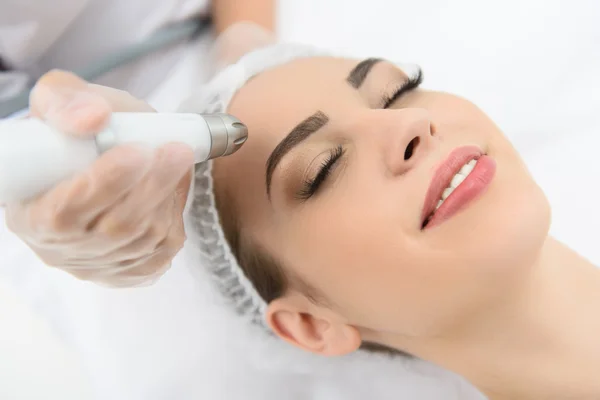 Cheerful woman getting laser therapy at spa salon — Stock Photo, Image