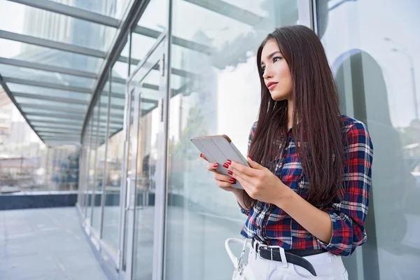 Mulher bonita relaxante com gadget perto do edifício — Fotografia de Stock