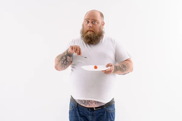 Fat surprised guy eats healthy food — Stock Photo, Image