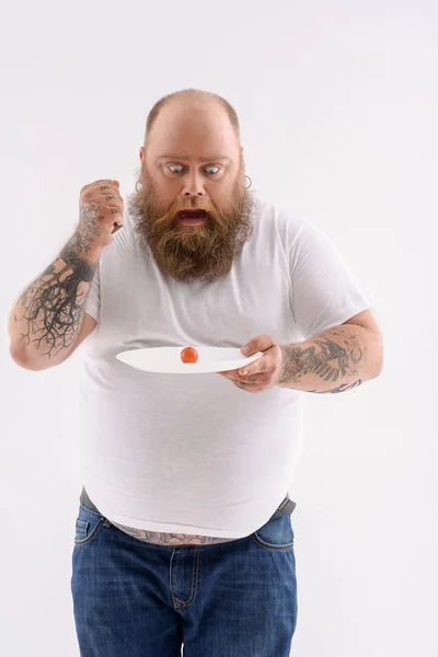 Thick guy eating vegetable with hunger — Stock Photo, Image