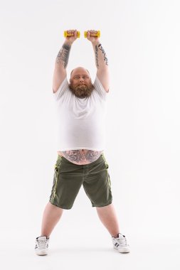 Şişman adam ağırlıkları ile egzersiz