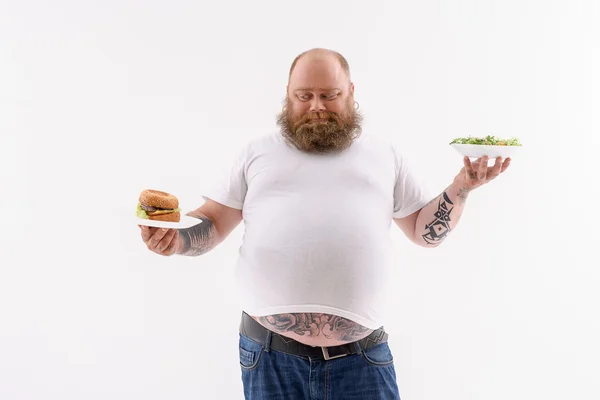 Tlustý muž upřednostňuje nezdravé jídlo — Stock fotografie
