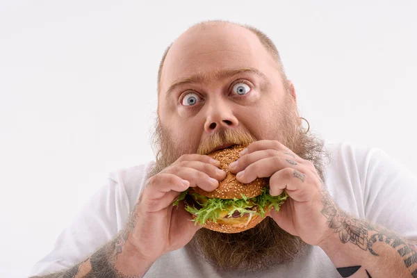 Fat guy eating unhealthy food — Stock Photo, Image