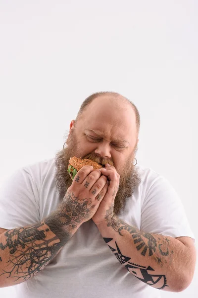 Chico grueso disfrutando de comida poco saludable — Foto de Stock