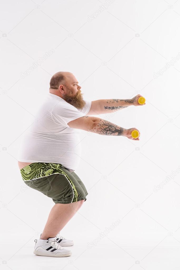 Fat guy training with weights — Stock Photo © iakovenko123 #119820182