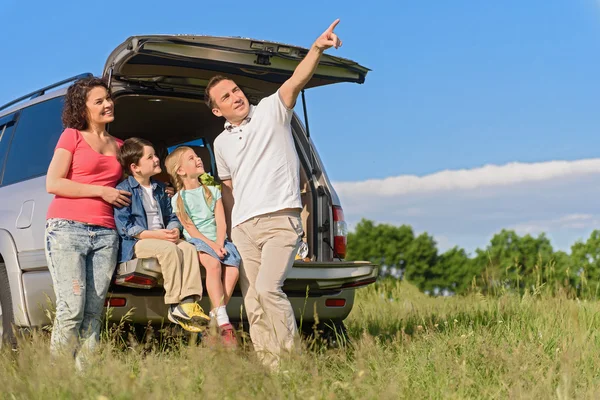 Sonriendo familia feliz y su coche — Foto de Stock