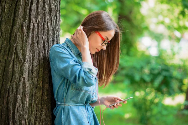 Chica bonita usando el teléfono en la naturaleza — Foto de Stock