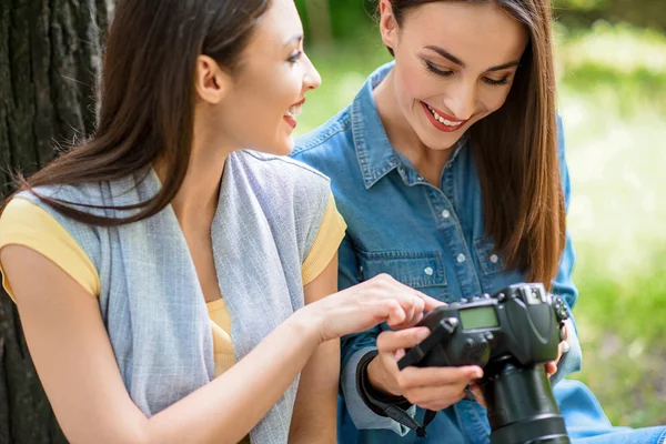 Glada unga damer tittar på skott i parken — Stockfoto