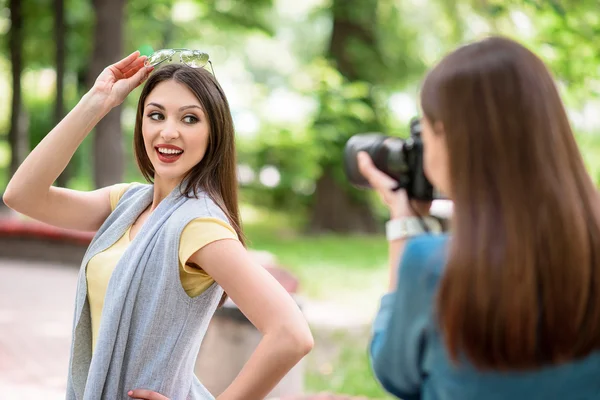 Lady fotograferar sin vän i naturen — Stockfoto