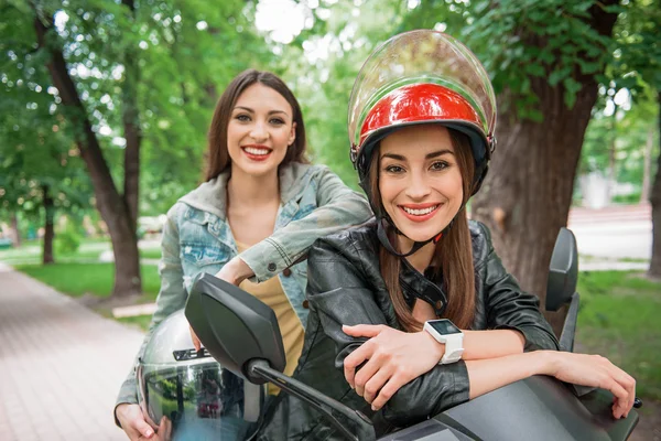 Joyful female friends enjoying travel on bike — Stock Photo, Image