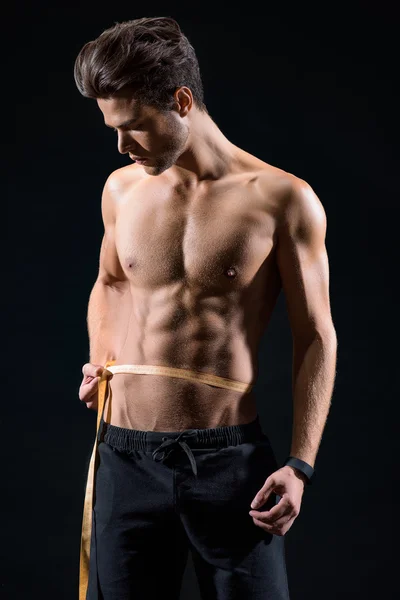 Atleta masculino confiante medindo a cintura — Fotografia de Stock